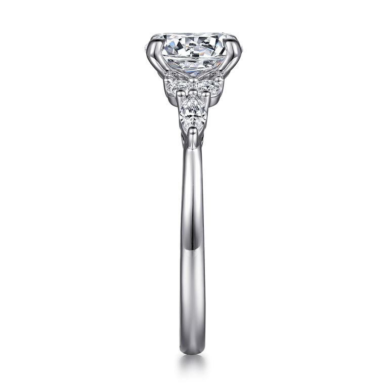 End view of a white gold diamond cluster engagement ring showing the raised center setting and diamond accents along the shoulder.