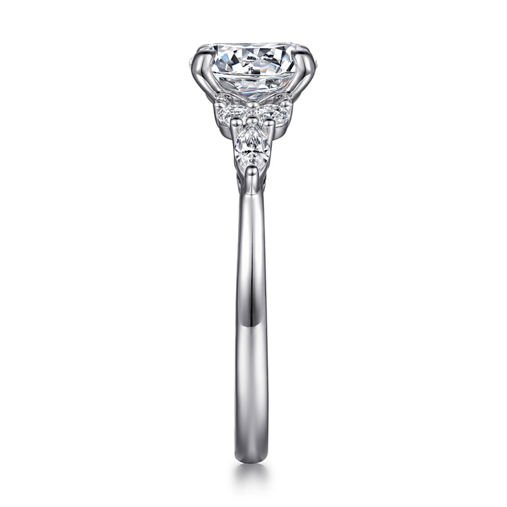 End view of a white gold diamond cluster engagement ring showing the raised center setting and diamond accents along the shoulder.