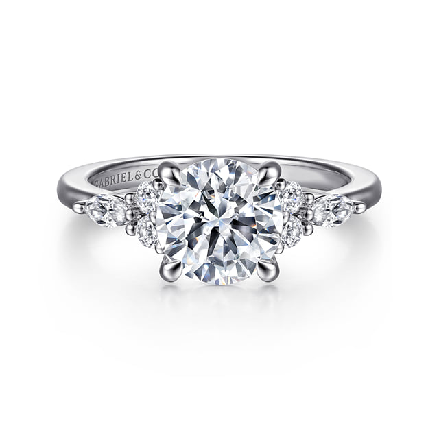Front view of a 14K white gold engagement ring with a round center diamond and round and marquise-shaped diamond side clusters.