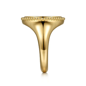 A side view of a yellow gold ring against a white background. The ring features an inlay of vibrant green malachite gemstone and yellow gold Bujukan beading.