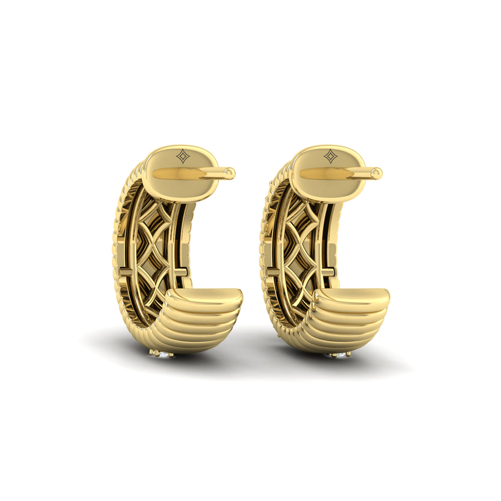 A back view of yellow gold hoop earrings set against a white background. The hoop earrings feature a sculptural, curved silhouette, an ocean wave-textured motif, and round-shaped diamonds.