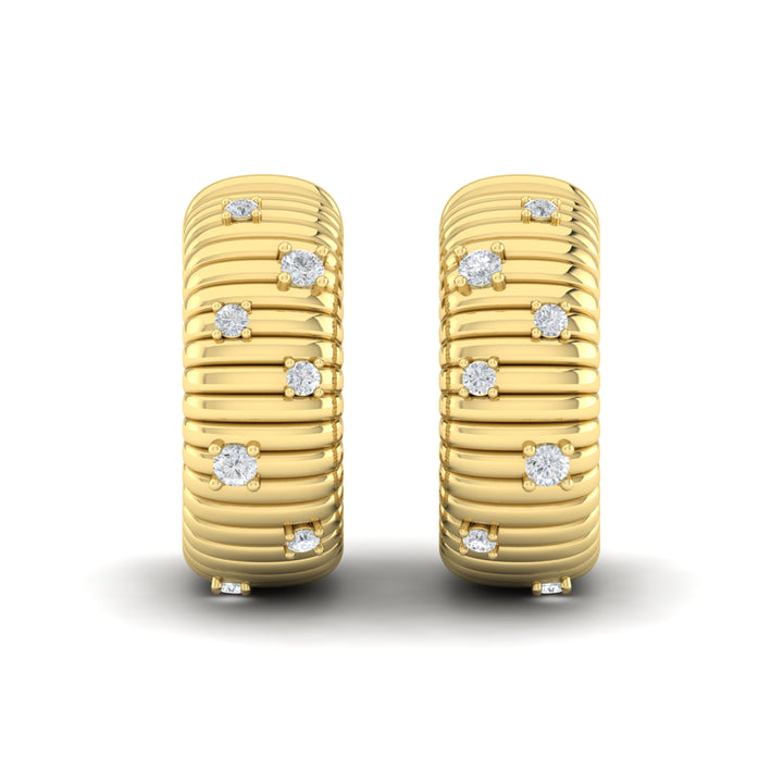 A front view of yellow gold hoop earrings set against a white background. The hoop earrings feature a sculptural, curved silhouette, an ocean wave-textured motif, and round-shaped diamonds.