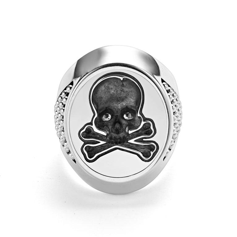 A front view of a signet ring against a white background. The ring features a skull motif that forms this Sterling silver signet ring.