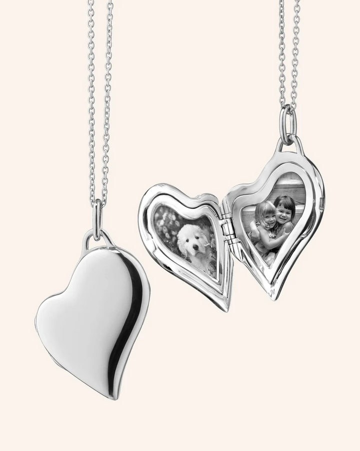 Sterling silver heart locket opened to show two heart-shaped photo compartments, with a black-and-white photo inside.