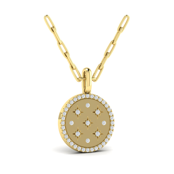 An angled view of a yellow gold pendant necklace is set against a white background. The circular pendant necklace features nine round-shaped diamonds, star motifs, a diamond-set halo, and a yellow gold chain.