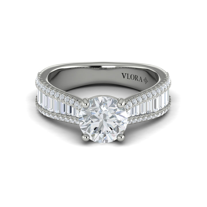 A front view of a white gold engagement ring is set against a white background. The engagement ring features a round center diamond, Vlora's signature V-shaped setting, a three-dimensional channel set baguette diamond band, and a cathedral design.