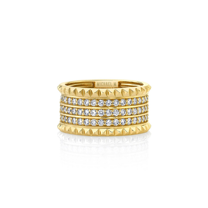 A front view of a yellow gold diamond ring against a white background. The ring features a gold band ring with three rows of sparkling round diamonds set pavé between two bands of miniature pyramid studs.