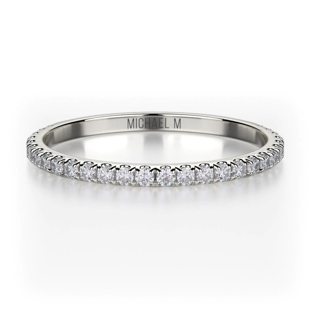 A front view of a white gold wedding band against a white background. The ring features a 3/4 eternity style with brilliant round-shaped prong-set diamonds.