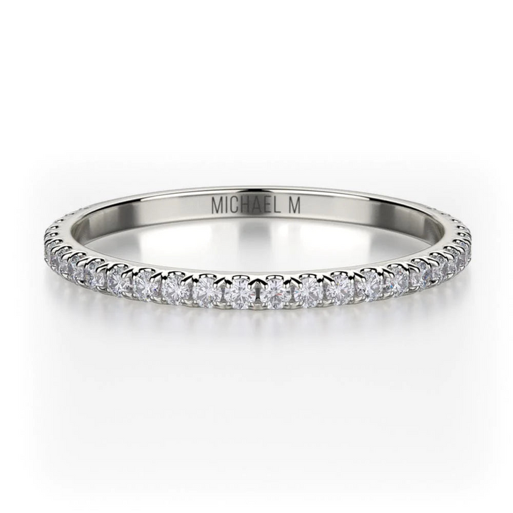 A front view of a white gold wedding band against a white background. The ring features a 3/4 eternity style with brilliant round-shaped prong-set diamonds.