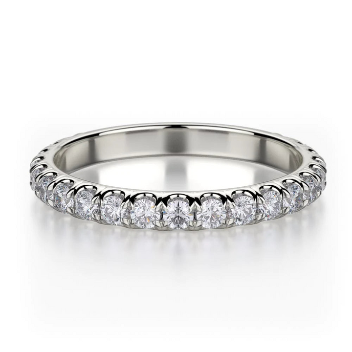 A front view of a white gold wedding band against a white background. The ring features a 3/4 eternity style with brilliant round-shaped prong-set diamonds.