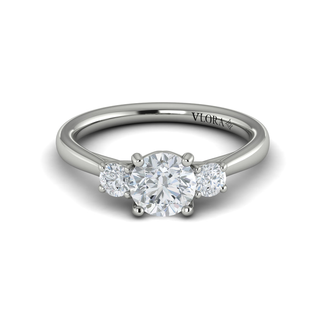 A front view of a white gold engagement ring is set against a white background. The engagement ring features a round center diamond flanked by two smaller round diamonds, set in an interlaced design.