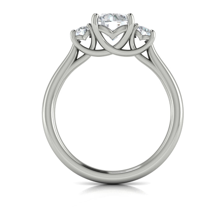 A top view of a white gold engagement ring is set against a white background. The engagement ring features a round center diamond flanked by two smaller round diamonds, set in an interlaced design.
