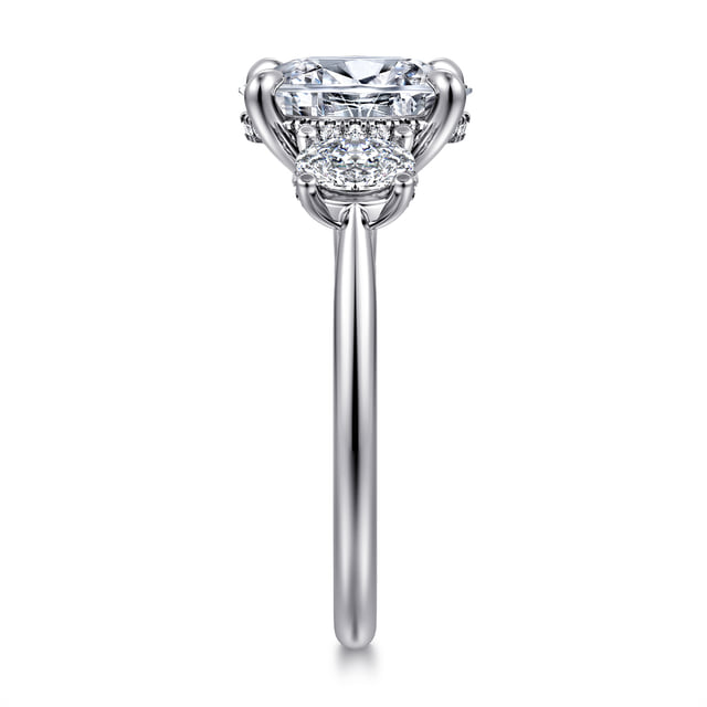 End view of an oval three-stone engagement ring showing a round side diamond and the hidden diamond halo beneath the center stone.