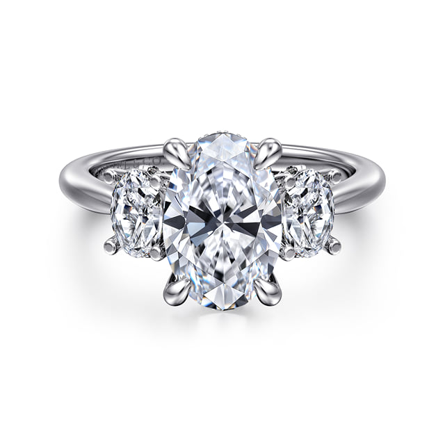 Front view of a 14K white gold three-stone engagement ring with an oval center diamond, round side diamonds and a tapered band.