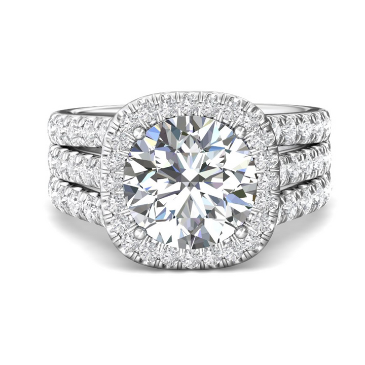 Front view of a 14K white gold engagement ring with a round center diamond, cushion-shaped diamond halo and triple split shank band.