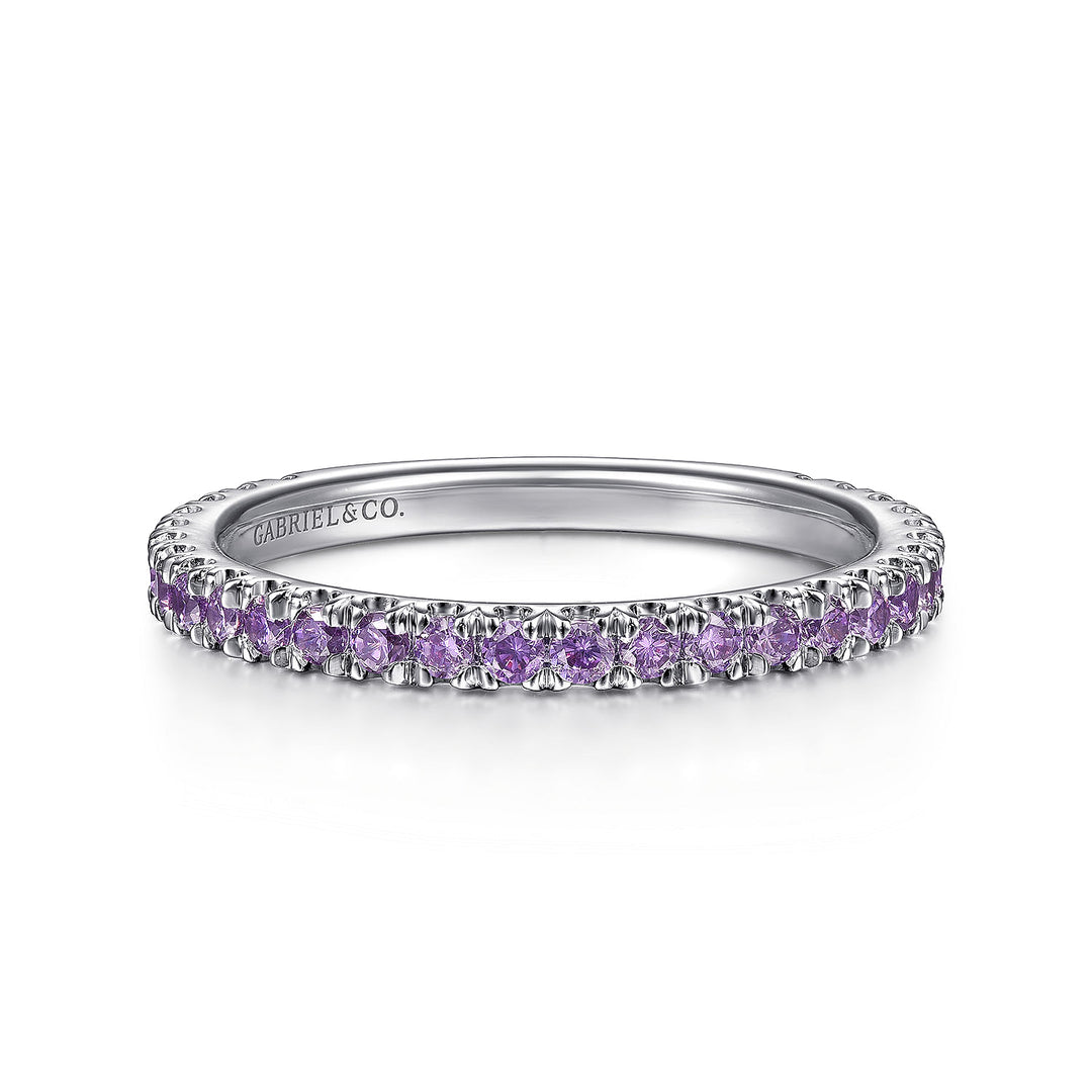 A front view of a white gold ring against a white background. The ring features amethyst gemstones set in place by small prongs in gleaming white gold.