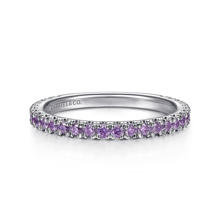 A front view of a white gold ring against a white background. The ring features amethyst gemstones set in place by small prongs in gleaming white gold.