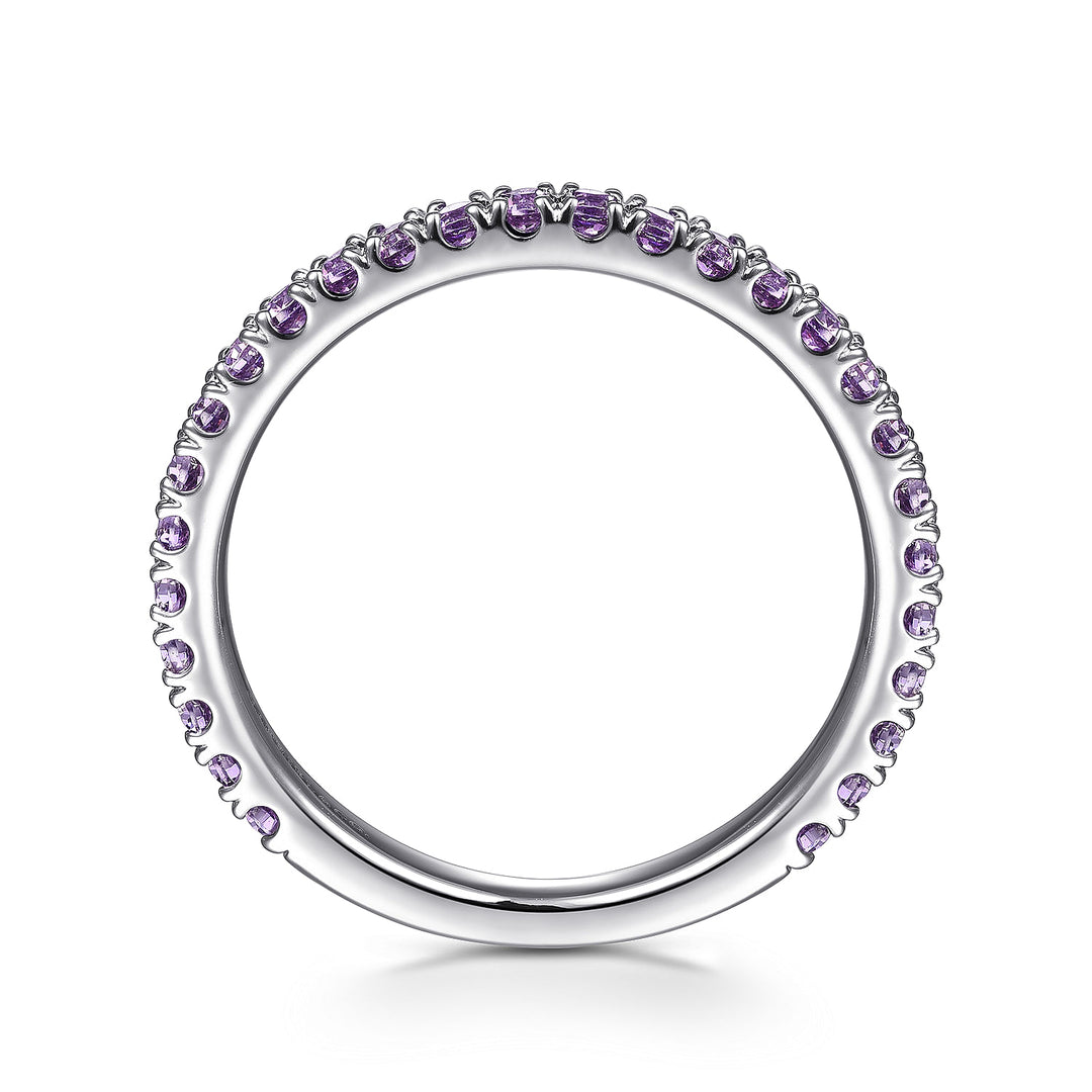 A side profile view of a white gold ring against a white background. The ring features amethyst gemstones set in place by small prongs in gleaming white gold.