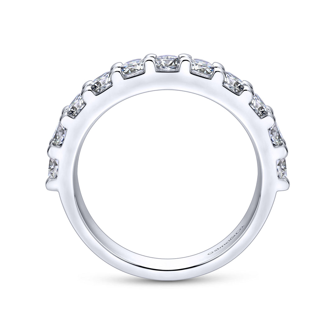 A side profile view of a white gold wedding band against a white background. The ring features a half-eternity style with a row of brilliant diamonds set in white gold.