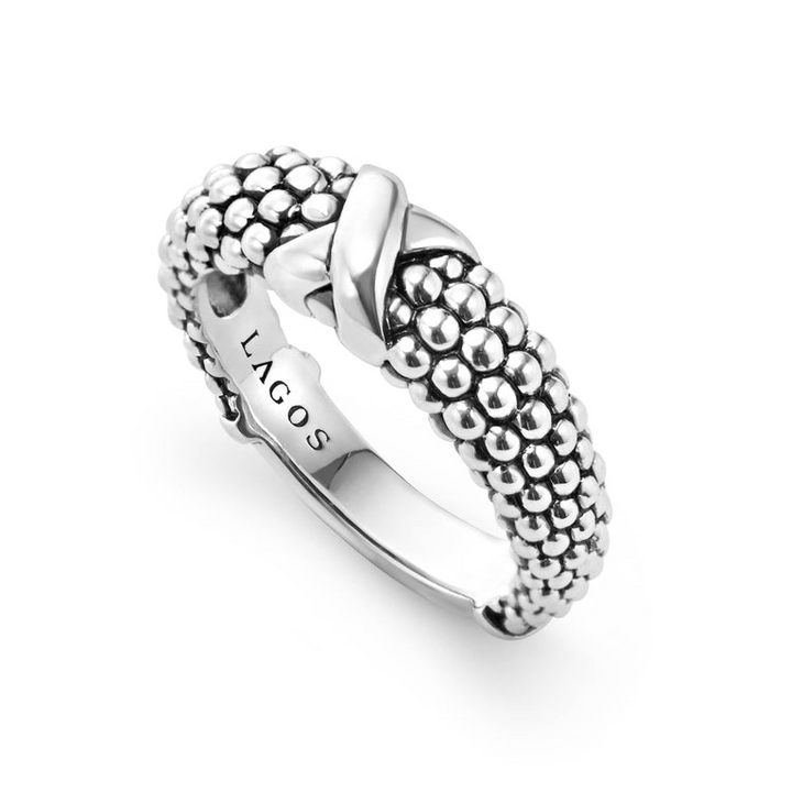 An angled view of a sterling silver ring against a white background. The ring features an X-shaped design and classic caviar beading.