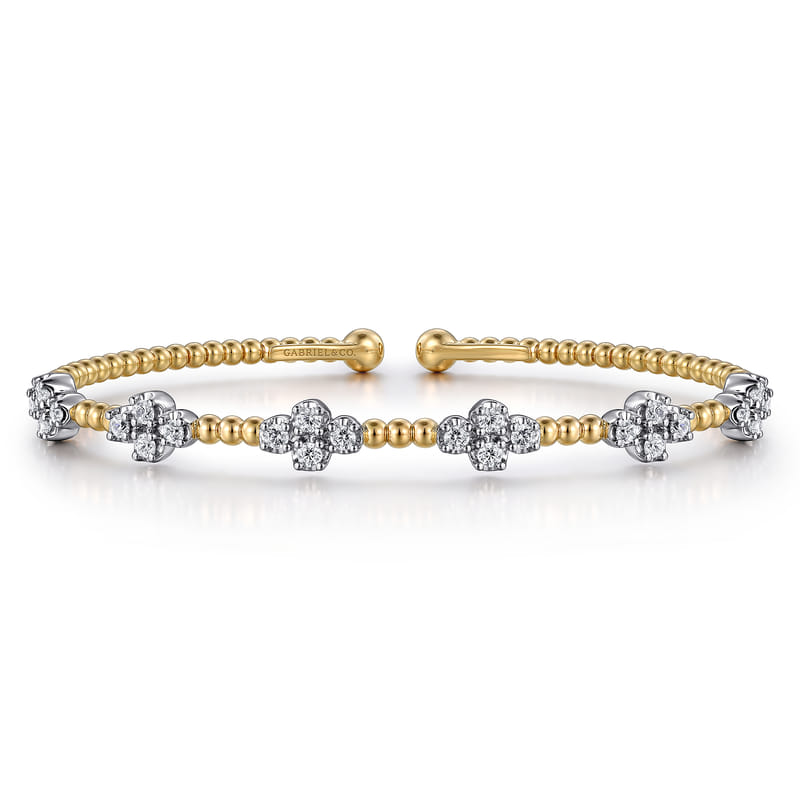 Angled view of the Gabriel & Co Bujukan bangle with its open design, elongated diamond tips and yellow gold beads