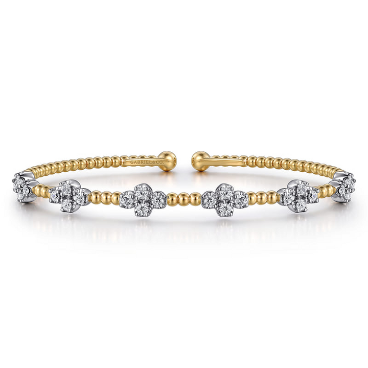 Angled view of the Gabriel & Co Bujukan bangle with its open design, elongated diamond tips and yellow gold beads
